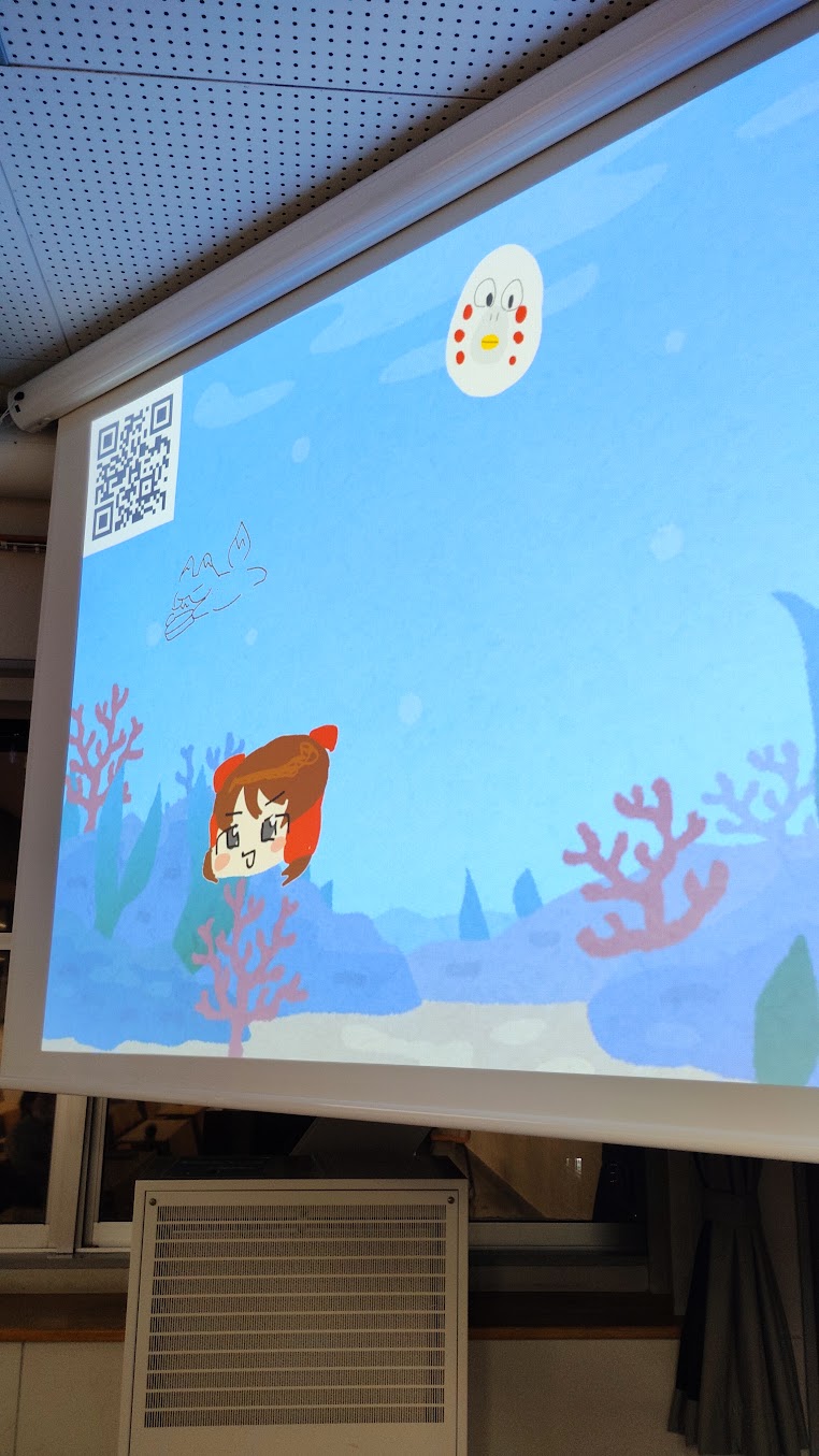 プロジェクターに映した水槽の中に、参加者の描いた絵が表示されている展示風景